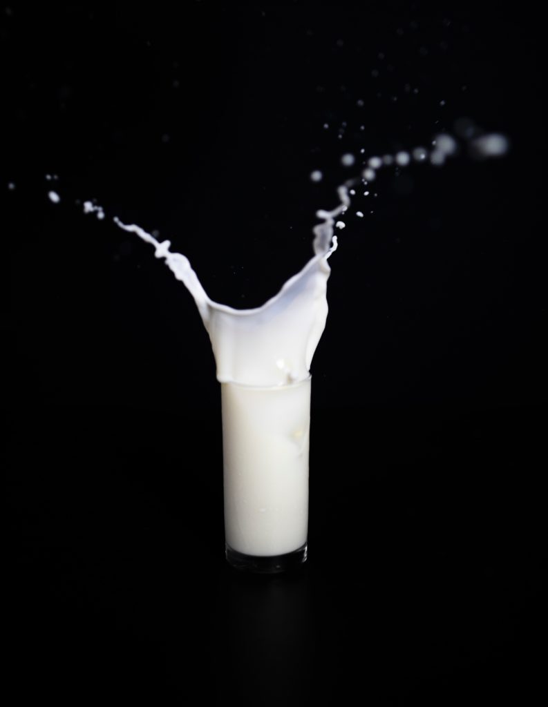 a glass of milk with a black background