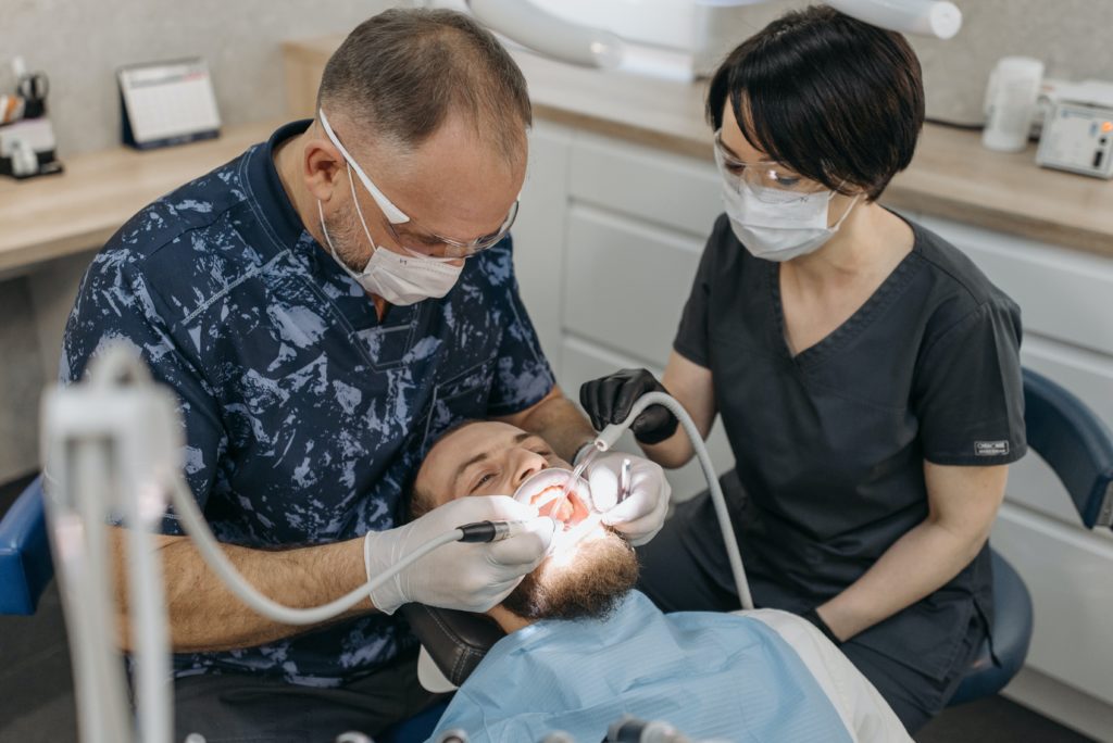 Dentist and his assistant working on a patient